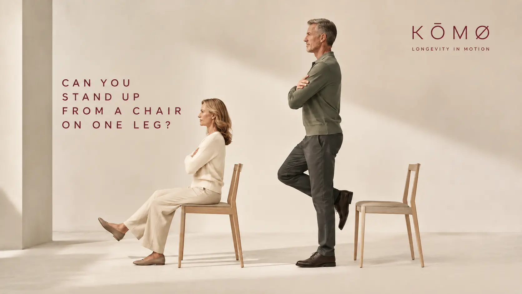 A seated woman and a standing man balancing on one leg beside two wooden chairs